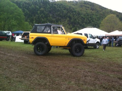 1992 Ford Bronco - Modified first-gen Ford Bronco with a soft top, seen at an outdoor event.