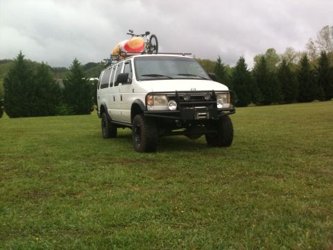 1992 Ford Bronco - This modified van is equipped for outdoor adventures with a kayak and bicycle secured to its roof rack.