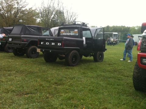 1992 Ford Bronco - Modified Ford Bronco pickup truck with a soft top and roof rack, seen at an outdoor event.