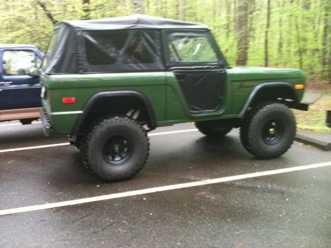 1992 Ford Bronco - A first-generation Ford Bronco, likely from the early 1970s, is seen parked next to another vehicle.