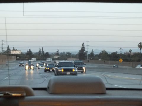 2003 Ford Crown Victoria - Twilight freeway traffic seen over the dashboard, a dark sedan and SUV clustered ahead.