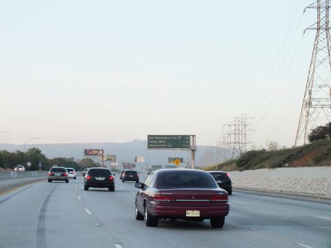 2003 Ford Crown Victoria - Maroon sedan passes under a green guide sign listing San Bernardino Fwy, Valley Blvd and Pomona Fwy.
