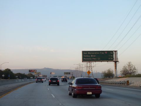 2003 Ford Crown Victoria - Dark red sedan approaches an overhead guide sign at twilight; San Bernardino Fwy 1/2 mile.