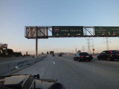 2003 Ford Crown Victoria - Large green guide sign marks 605 South thru traffic and I-10 exits as cars pass at twilight.