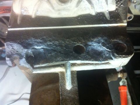 1989 Ford Bronco - This image shows a close-up of a cast iron engine block part, likely from an older vehicle, exhibiting signs of wear and corrosion.