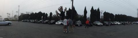 2003 Ford Crown Victoria - Panoramic view of a packed lot with rows of vehicles and attendees on a cloudy day.
