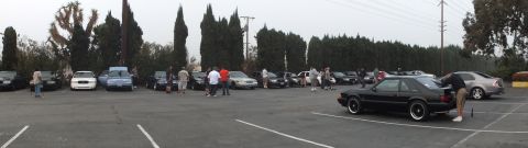 2003 Ford Crown Victoria - Wide view of a parking lot meet, a black notchback coupe parked at far right.