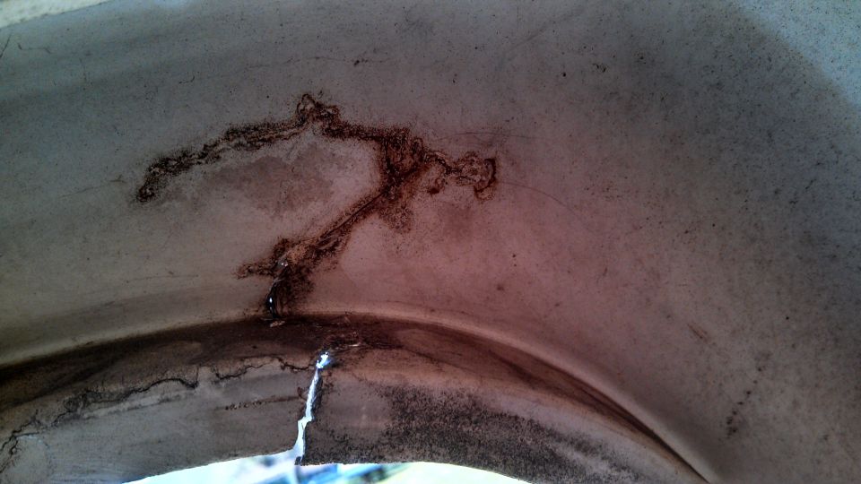Interior wheel well with cracks and dark staining