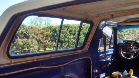 1979 Ford Bronco - Interior view of a 1979 Ford Bronco, showing the dashboard and sliding rear windows.