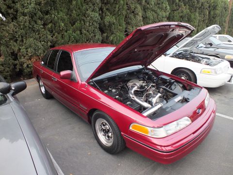 2003 Ford Crown Victoria - Maroon Crown Victoria sits low on polished alloys, hood up to show an intercooler pipe.