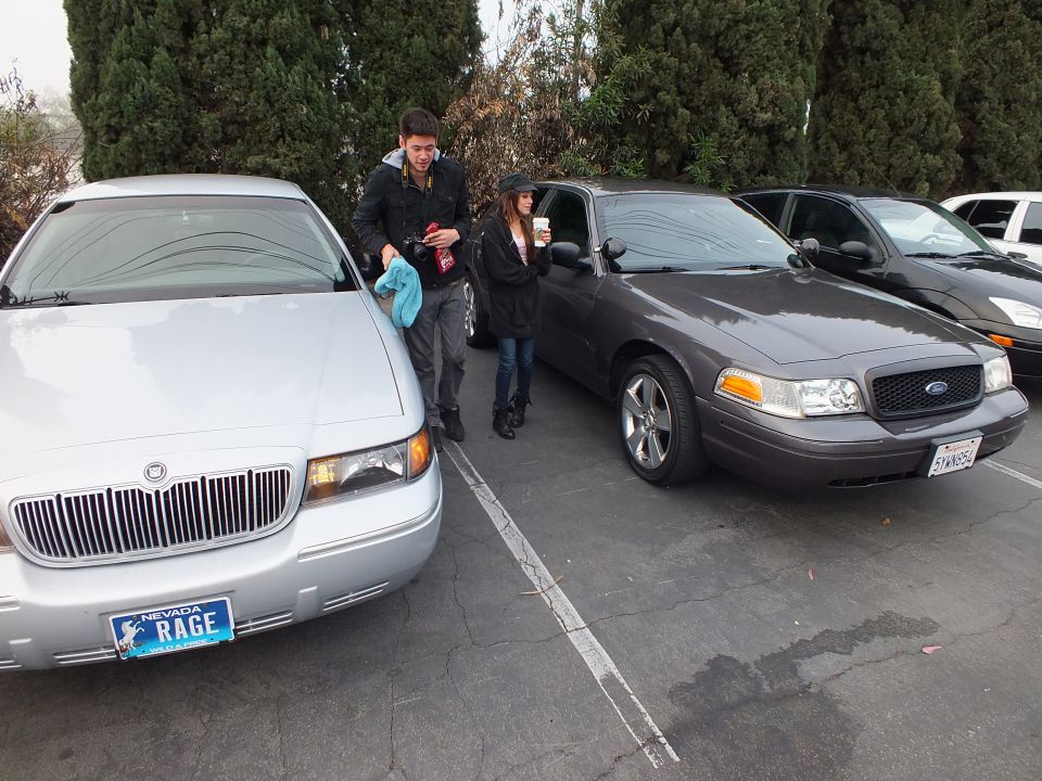 Silver Mercury Grand Marquis with Nevada RAGE plate beside gray Ford Crown Victoria