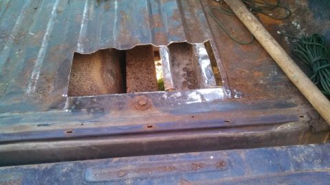 1979 Ford Bronco - A heavily rusted truck bed shows significant damage with a large opening in its floor.