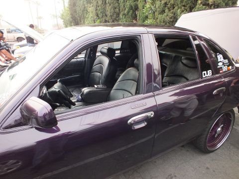 2003 Ford Crown Victoria - Black leather interior of a purple Ford Crown Victoria seen through tinted windows with a DUB sticker.