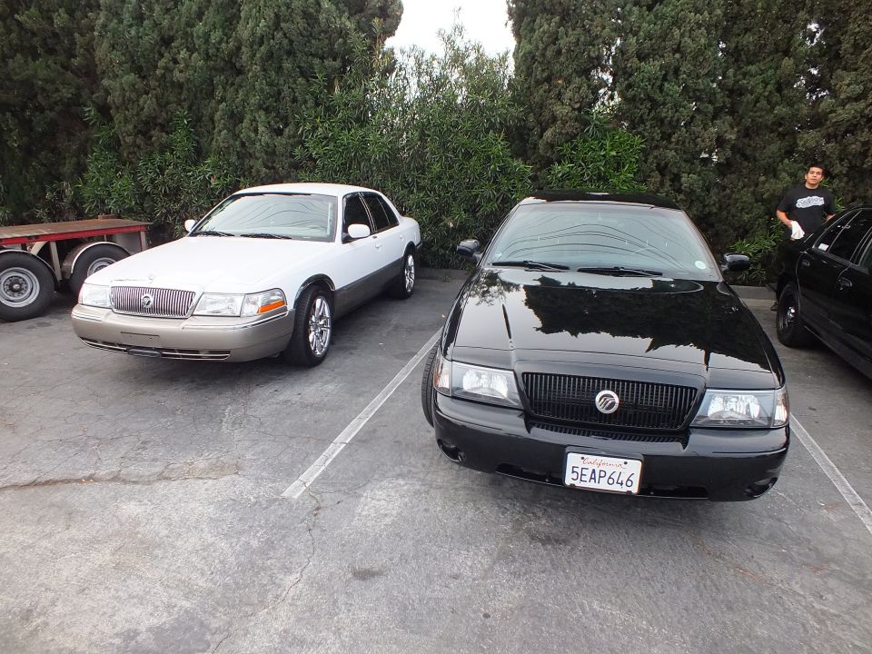 White Mercury Grand Marquis and black Mercury Marauder parked side by side at car meet