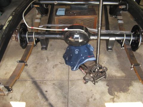 1963 Ford Galaxie - The rear axle assembly of a vehicle is shown, partially covered by a blue cloth and supported by a jack.