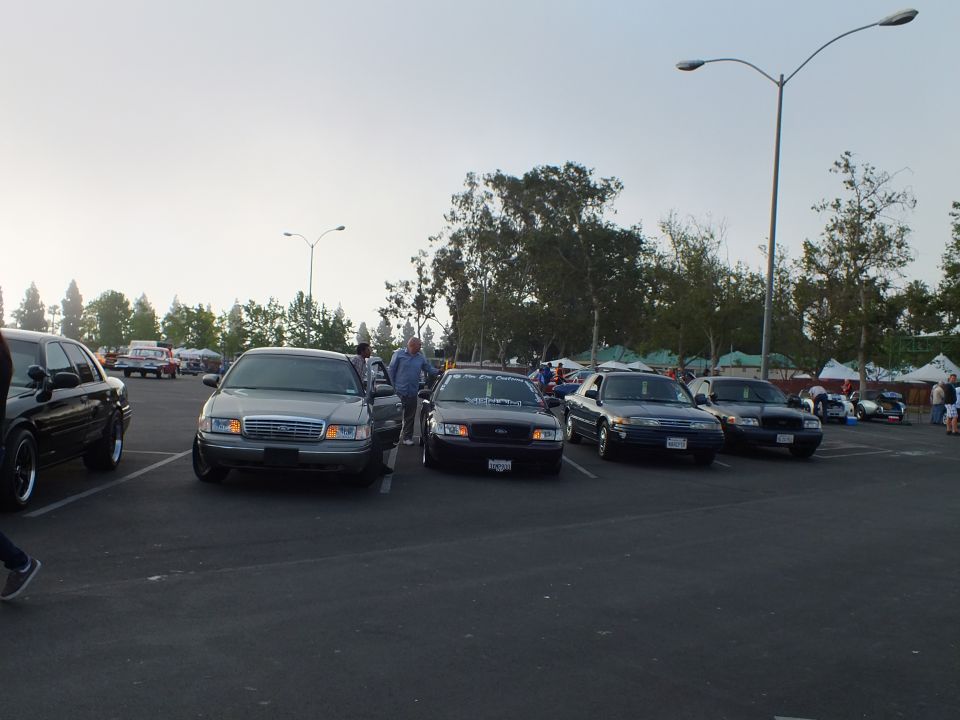 Front view of four full-size sedans parked nose-out under an open evening sky