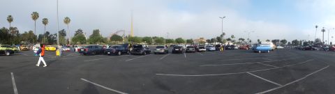 2003 Ford Crown Victoria - panoramic shot of a parking-lot car meet showing many parked cars, people walking, and a roller coaster in the background.