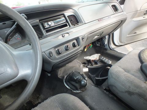 2003 Ford Crown Victoria - gray interior of a Ford Crown Victoria showing an aftermarket stereo, cloth seats and an open shifter hole cut into the floor.