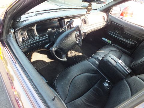 2003 Ford Crown Victoria - View into a sedan showing its dashboard, center stack, steering wheel and custom diamond-stitched black leather seats.
