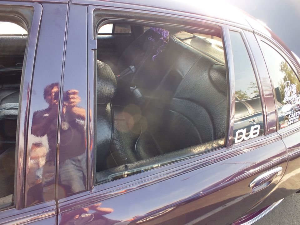 Rear window of a purple sedan with a DUB decal and black leather rear seats inside