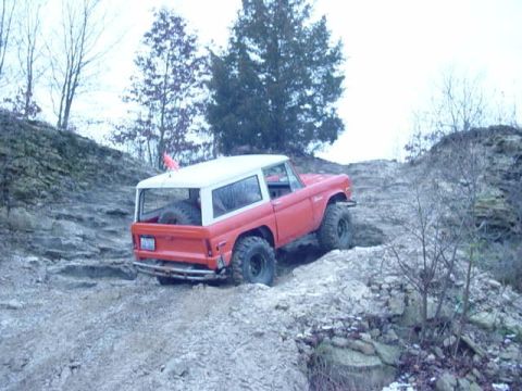 1992 Ford Bronco - This classic Ford Bronco is tackling a challenging off-road trail with steep inclines and loose rocks.