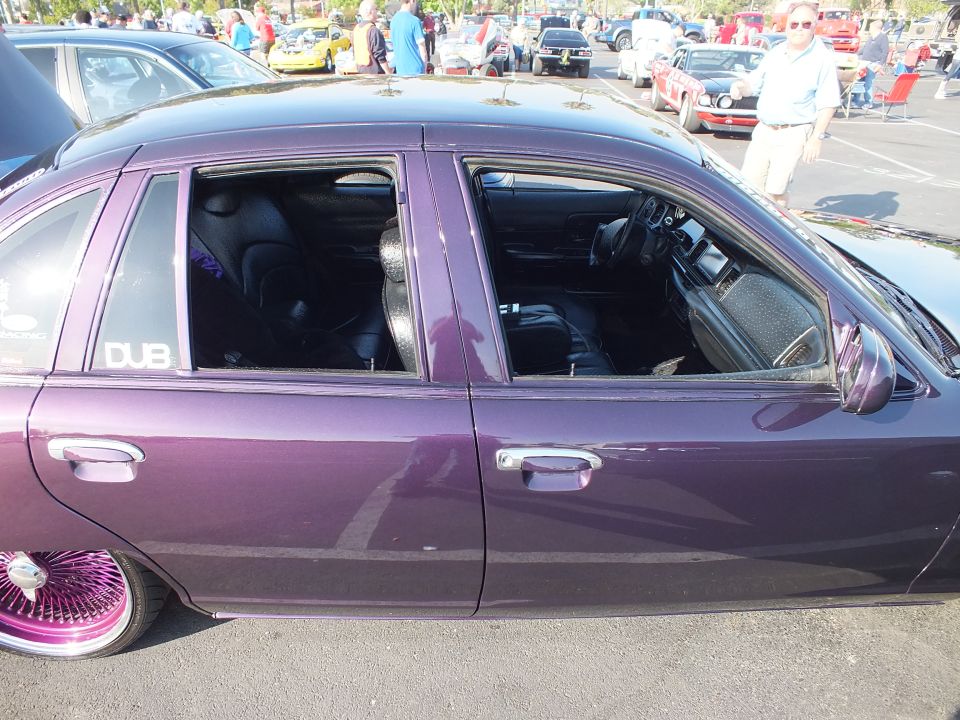Close side view of a purple sedan's doors and windows showing a black interior and a DUB decal