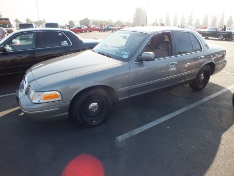 2003 Ford Crown Victoria - gray Ford Crown Victoria full-size sedan sits on black steel wheels in a sunlit show parking lot.