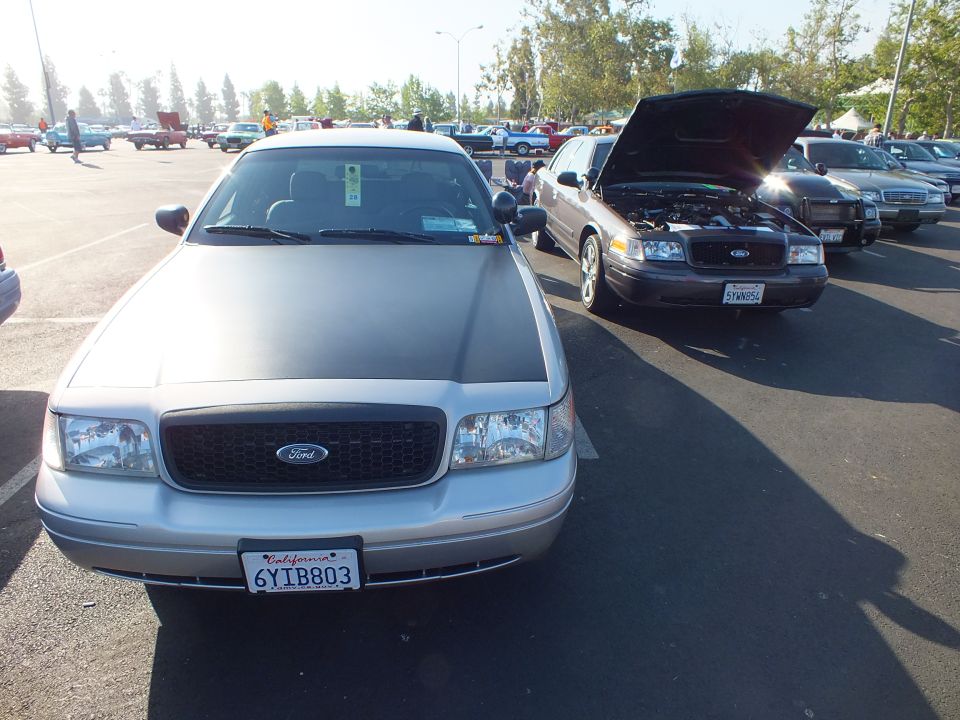 Front view of a silver Ford sedan with Ford grille and California plate 6YIB803 beside other Fords