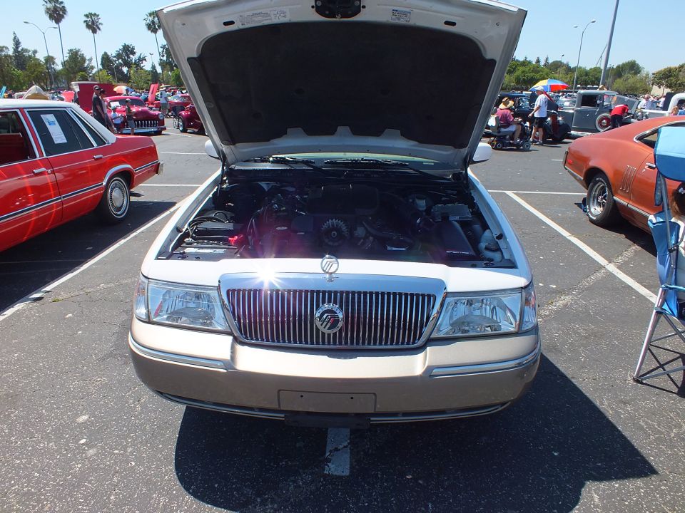 White and tan Mercury sedan front with chrome grille and open hood