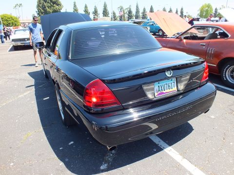 2003 Ford Crown Victoria - Rear of a black four-door Mercury sedan showing taillights, trunk badging, and California-style plate AXV7617.