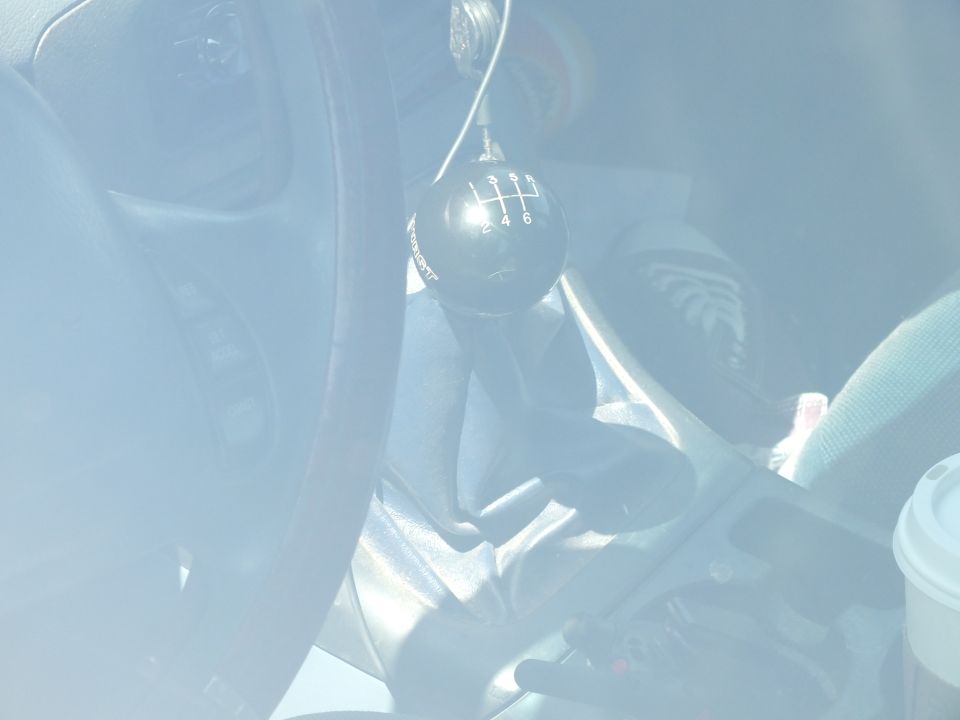 Close-up of a manual gear shifter with six-speed pattern knob