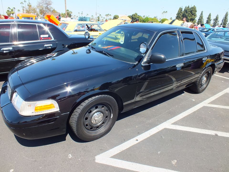 Black Ford sedan with black steel wheels at a car show