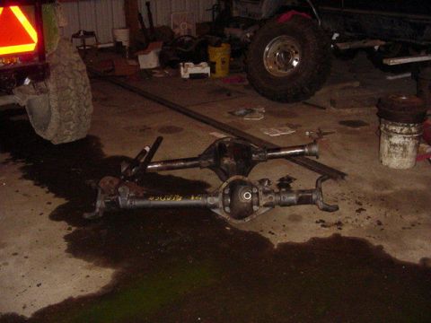 1992 Ford Bronco - Two Ford Bronco rear axles are on the floor of a garage, with one axle clearly labeled "1991 Bronco".