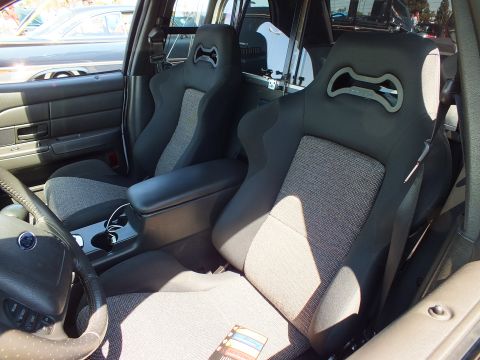 Front seats of a vehicle replaced with gray and black sport bucket seats and a console