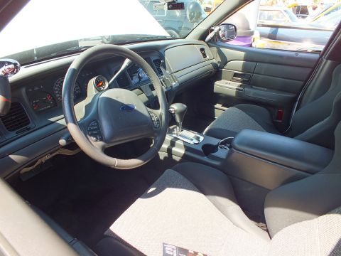 Interior of a Ford sedan with gray cloth sport seats, console shifter and Ford steering wheel