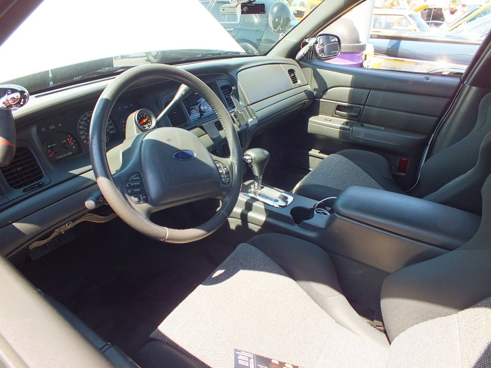 Interior of a Ford sedan with gray cloth sport seats, console shifter and Ford steering wheel