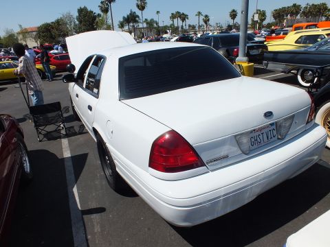 White Ford Crown Victoria sedan rear quarter with open trunk and GHST VIC license plate