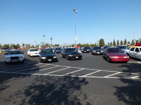 Silver, black and red full-size sedans parked across a sunny lot