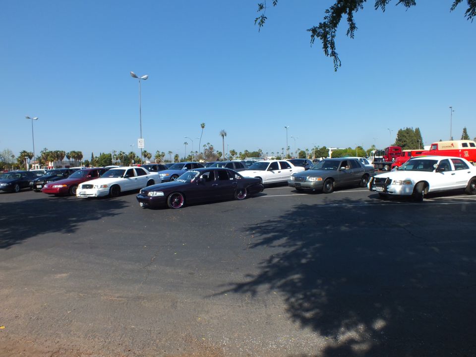 White, purple and dark sedans with a red fire truck in a sunny lot