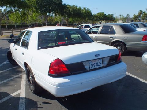 Rear of a white Ford sedan with California plate 6PFN439 in a parking lot