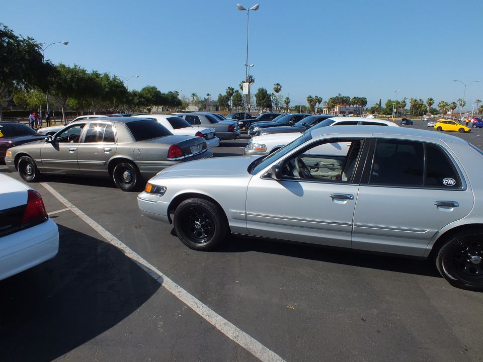 Silver Mercury sedan with black wheels parked beside a gray car and white sedan