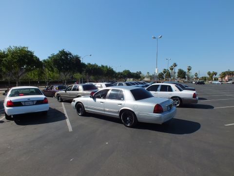 Silver sedan on black wheels parked among white and gray cars in a wide lot