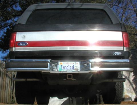 1988 Ford Bronco - Rear view of a black Ford Bronco SUV with red and chrome tailgate trim, dual tube bumper, and a Virginia 'Irnclad' vanity plate dated '05,…