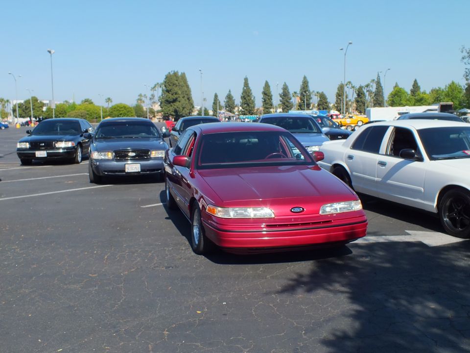 Maroon Ford full-size sedan parked front-out among other cars in a lot