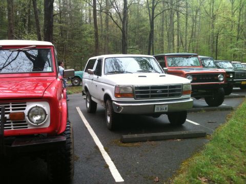 1992 Ford Bronco - A white 1992 Ford Bronco is parked in a lot alongside several other Ford Broncos.