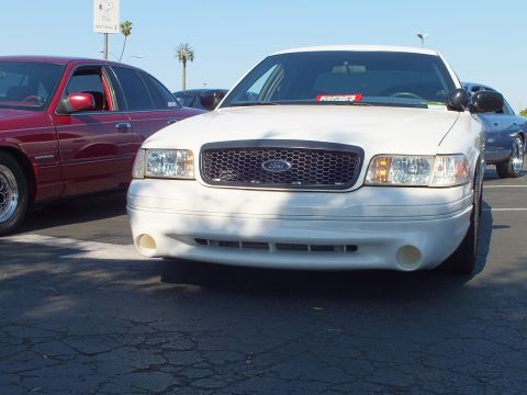 Front view of a white Ford Crown Victoria with a windshield sign