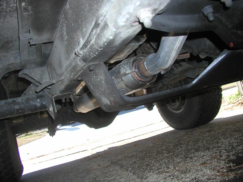Underbody exhaust and catalytic converter routing on a lifted truck with rock slider