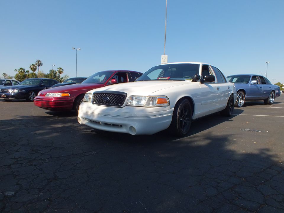 White lowered Ford Crown Victoria with black wheels among parked cars