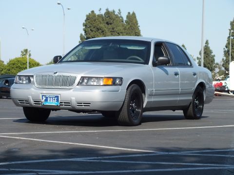 Silver Mercury Grand Marquis with black wheels parked, front three-quarter