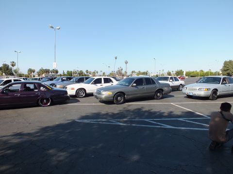 Maroon lowered sedan, silver and white sedans in a parking lot